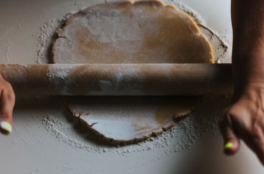 person rolling pin on a dough