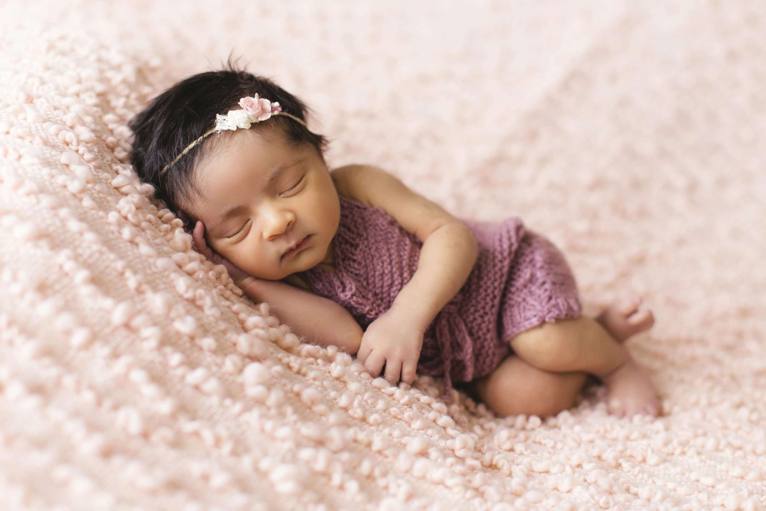  toddler lying on pink fleece pad