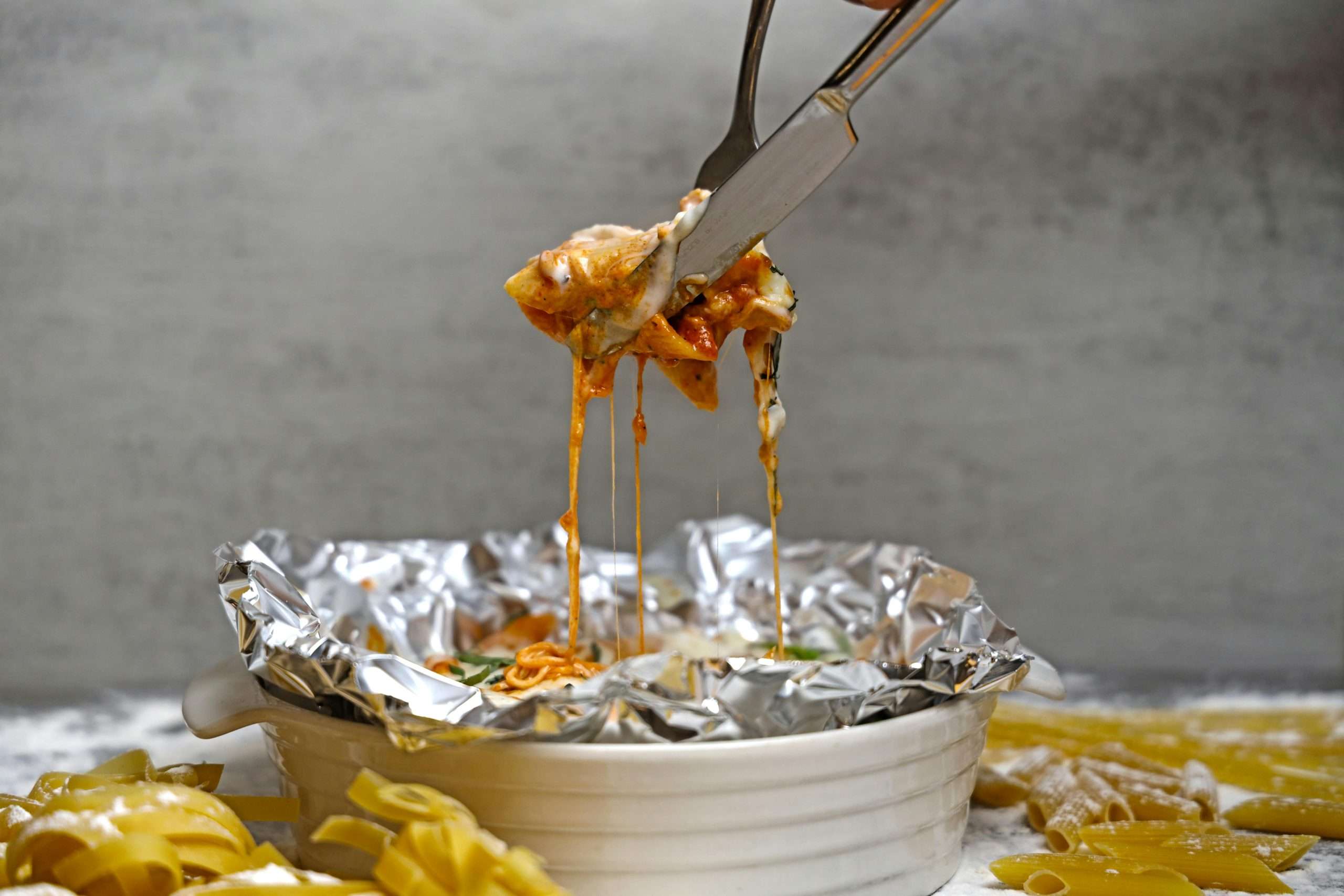 foil-packed baked pasta in a ceramic bowl