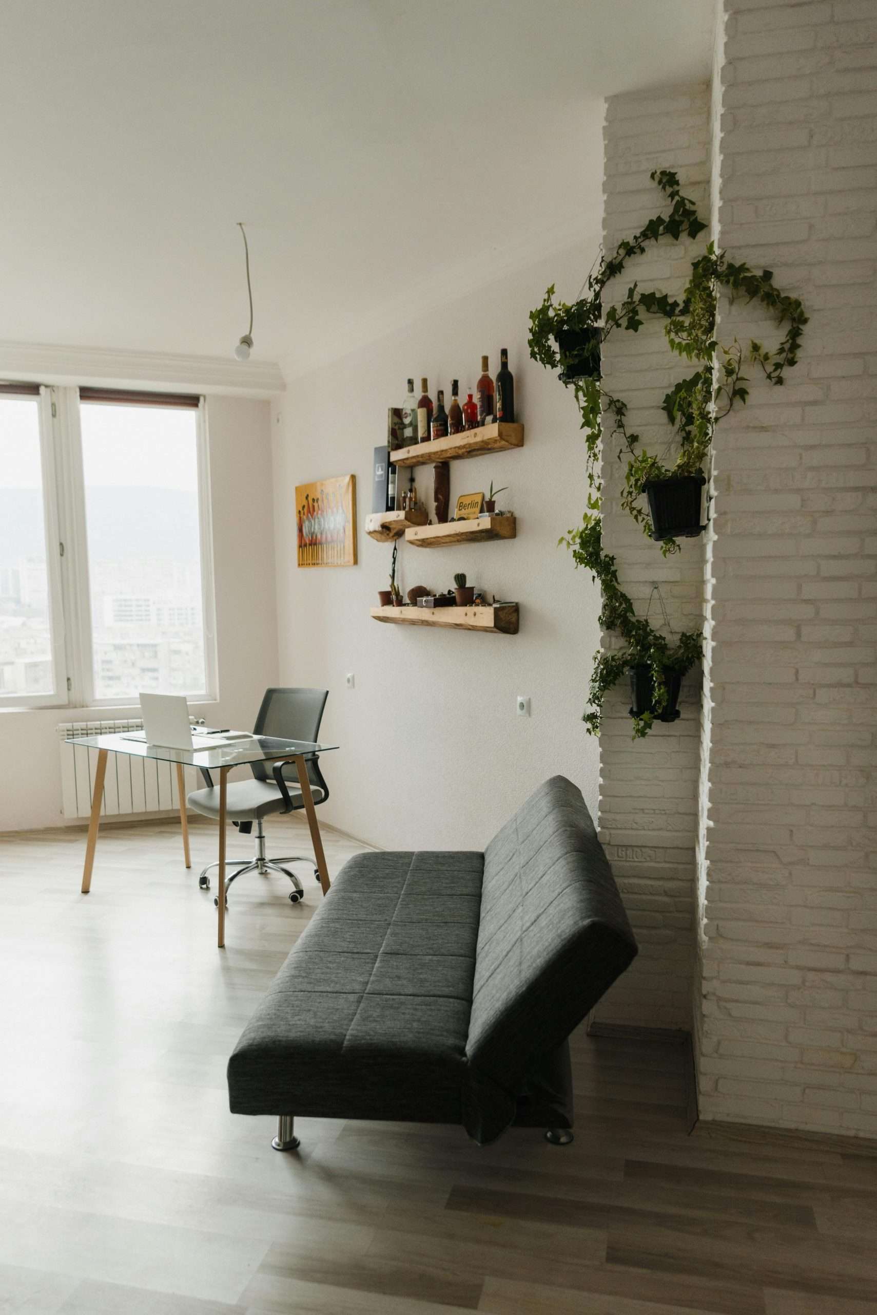 gray sofa bed near brick wall with vine plants