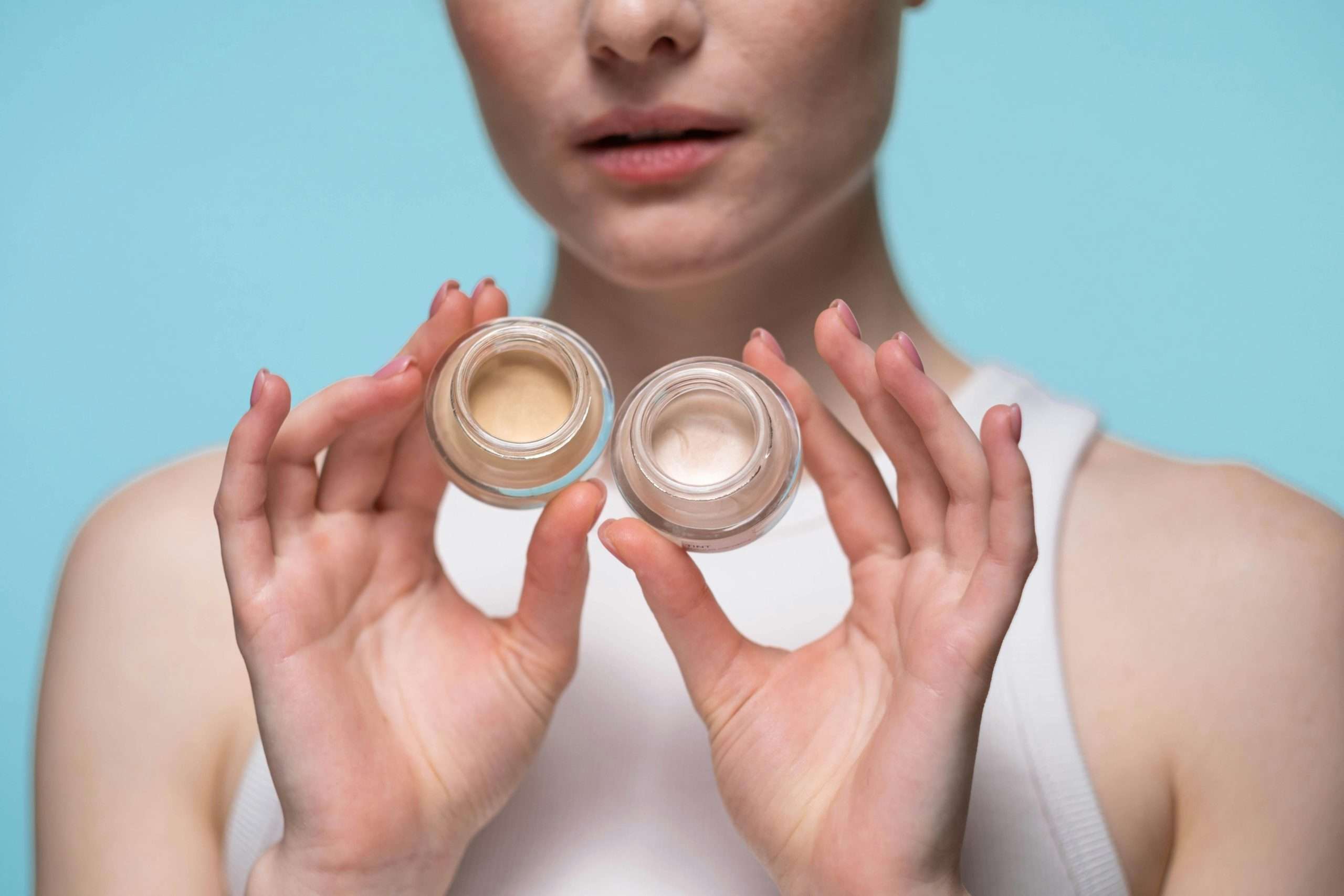 crop photo of woman holding cosmetic products