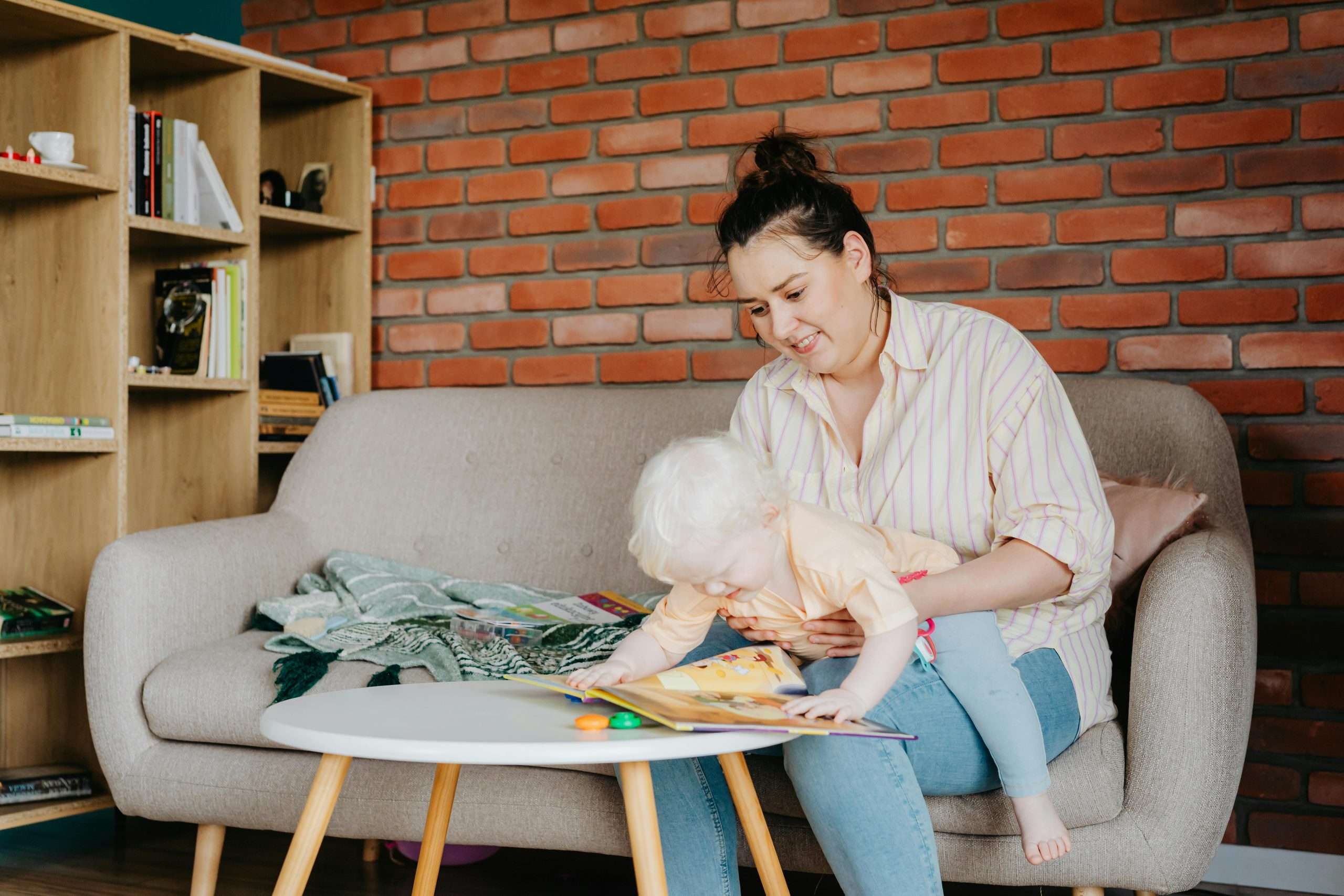 Mother sitting on a sofa holding baby on her lap