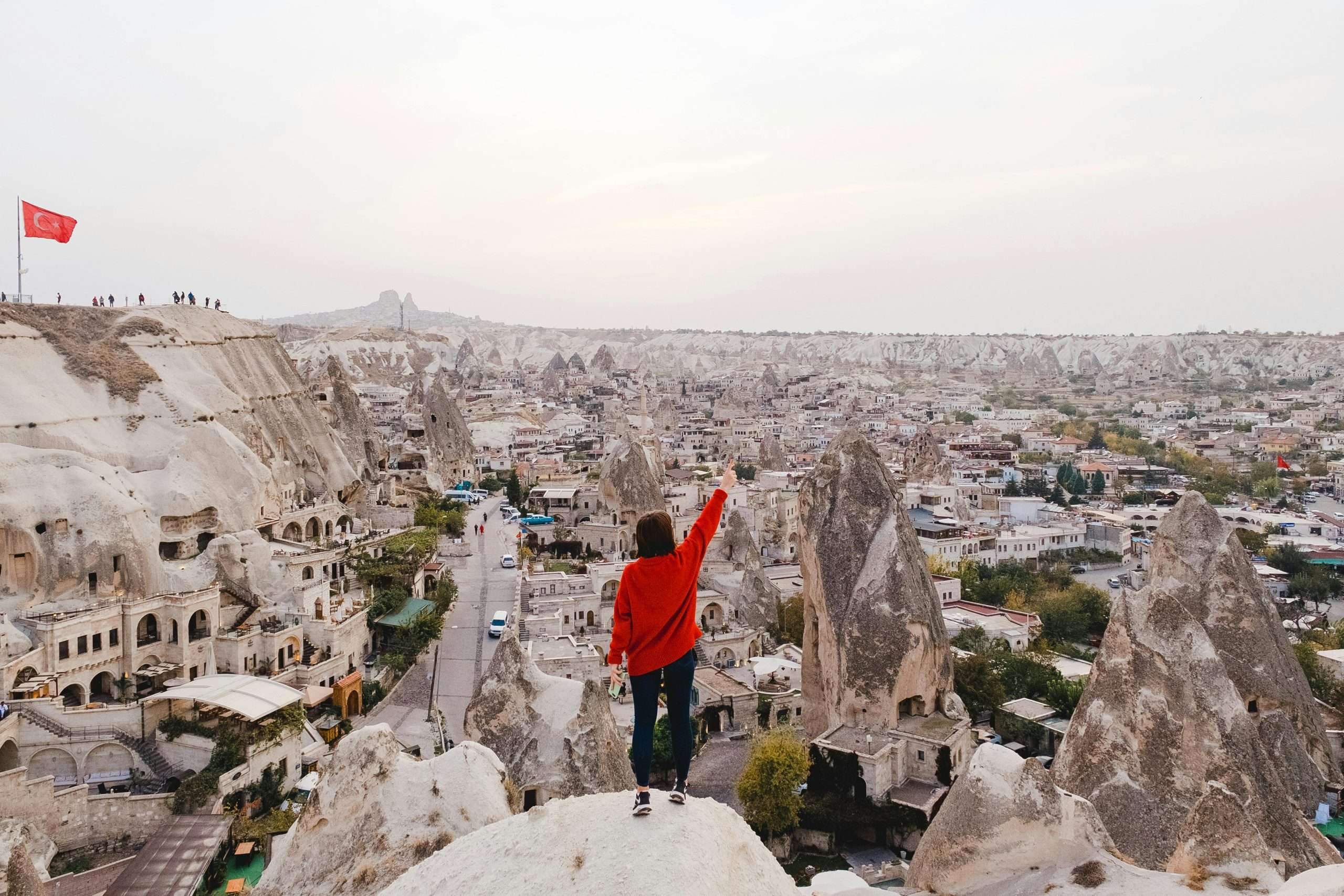 a person wearing red long-sleeved shirt standing on a rock