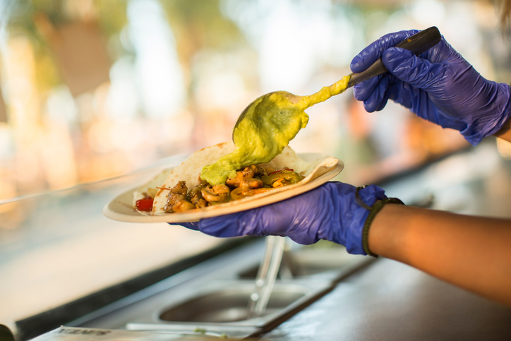 Chef preparing tacos with guacamole in a food truck